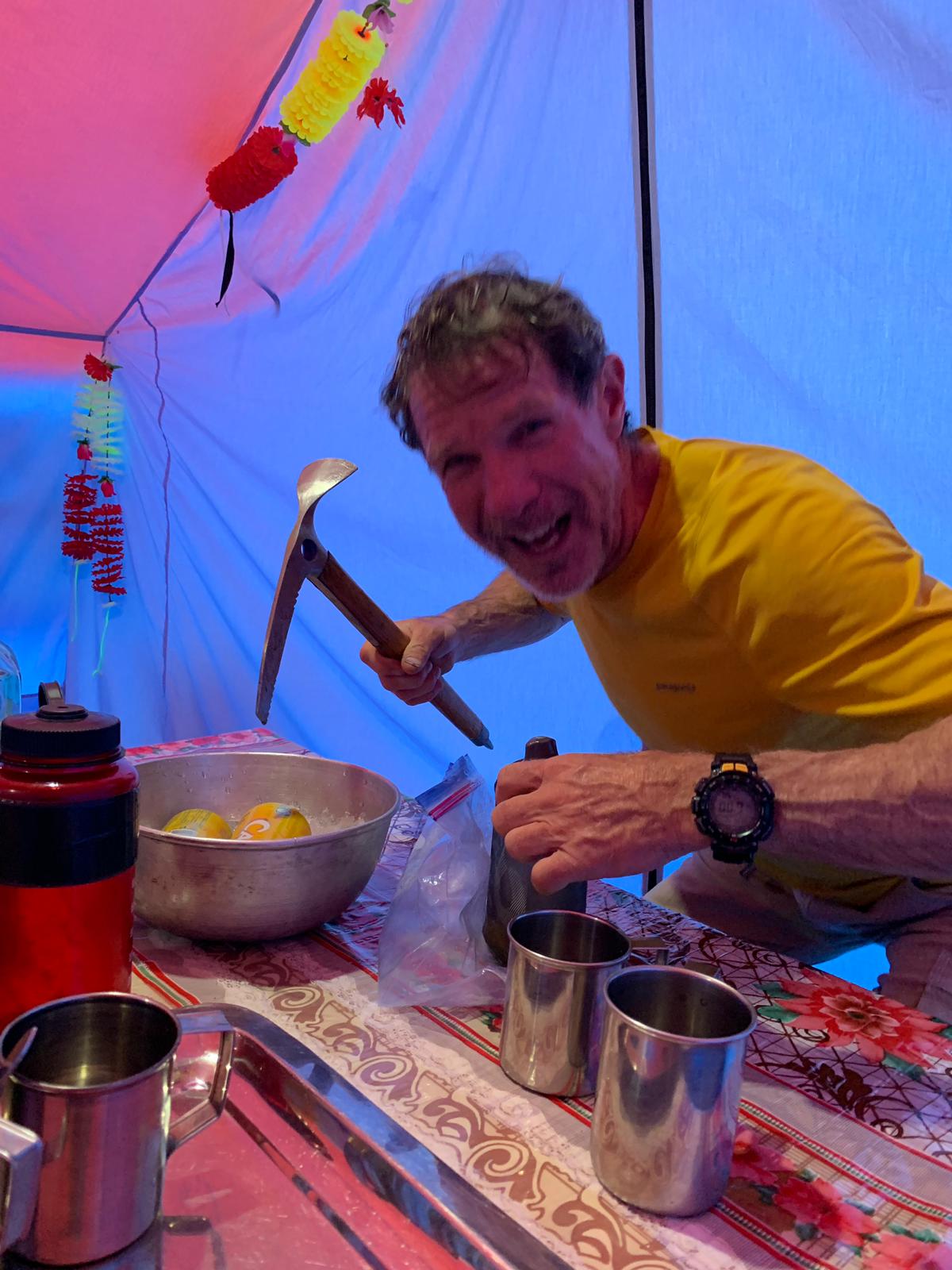 Rick chipping ice with a wooden ice axe, for gin and tonics in base camp