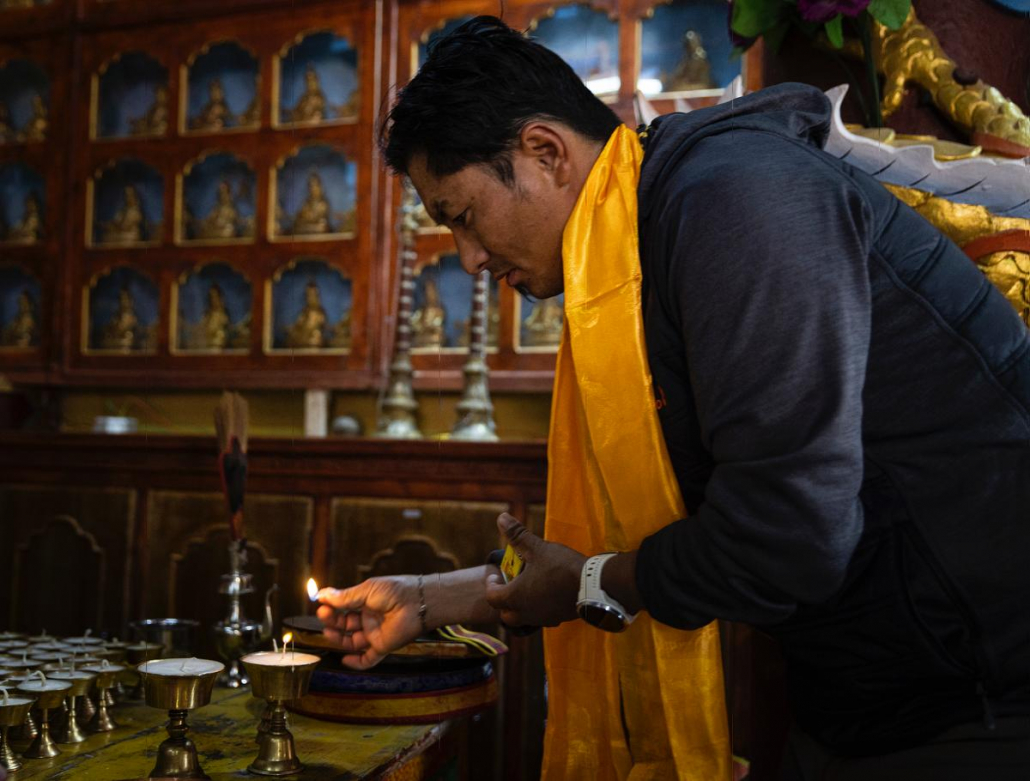 Aang Phurba Sherpa lighting butter lamps in a Buddhist gompa in Samagaun. Photo: Terray Sylvester