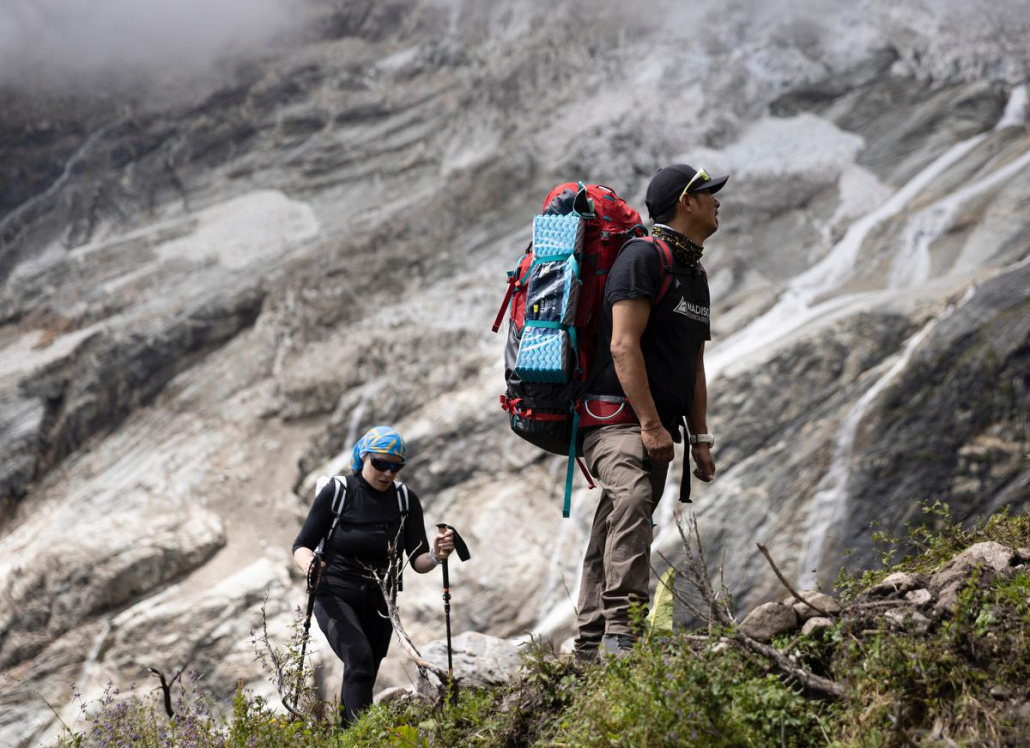 Our climber, Nancy, hiking toward base camp with Aang Phurba Sherpa. Photo: Terray Sylvester