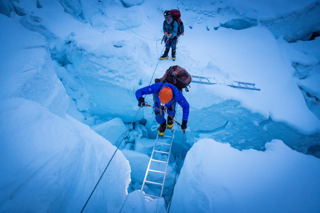 Climber, Erwin Visser crossing a ladder in the Khumbu Icefall. (Photo: Terray Sylvester)