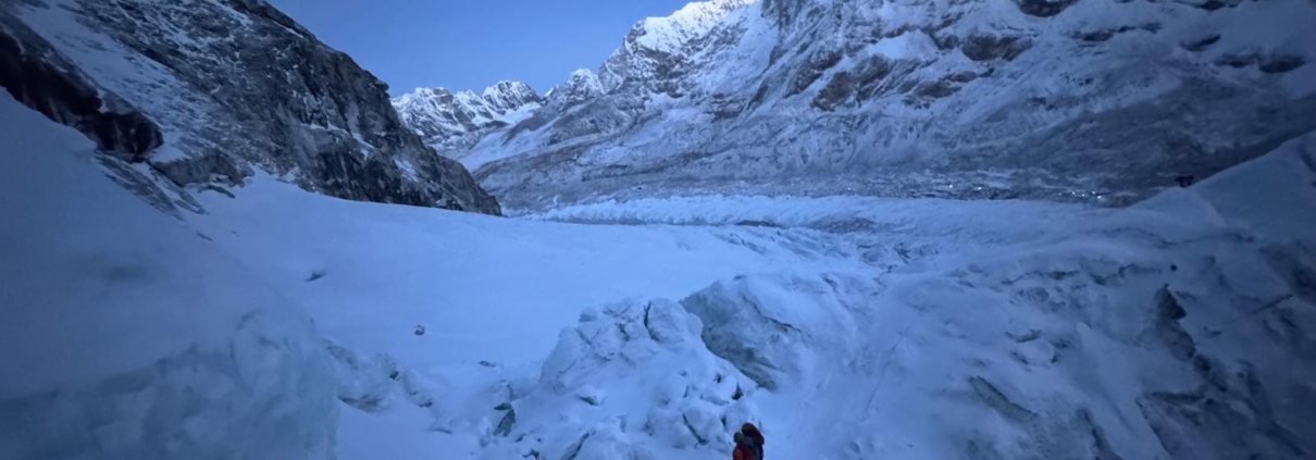 Climbing in the early morning hours through the Khumbu Icefall with Pumori and Everest Base Camp behind.