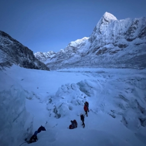 Climbing in the early morning hours through the Khumbu Icefall with Pumori and Everest Base Camp behind.