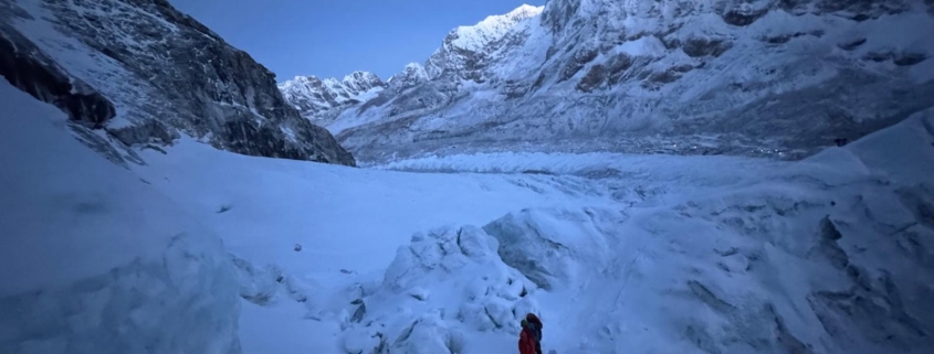 Climbing in the early morning hours through the Khumbu Icefall with Pumori and Everest Base Camp behind.