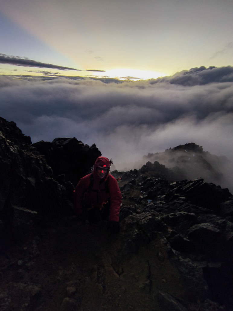 The sun starting to rise while climbing above the clouds.